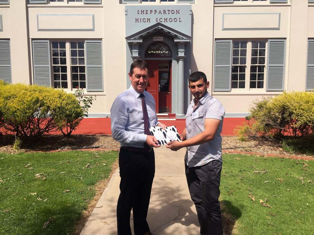 Hussam Saraf presenting Ask the Cows outside the entrance of Shepparton High School.