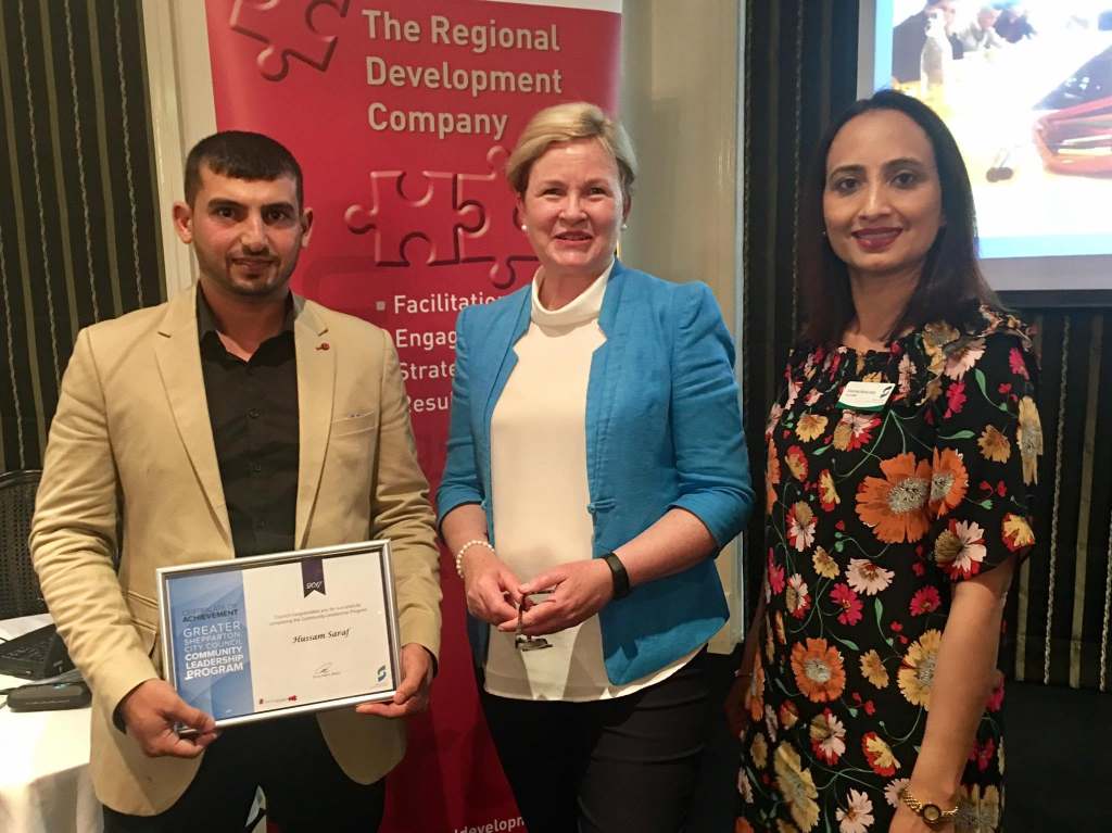 Hussam Saraf holding his Certificate of Achievement for the 2017 Community Leadership Program alongside two people.