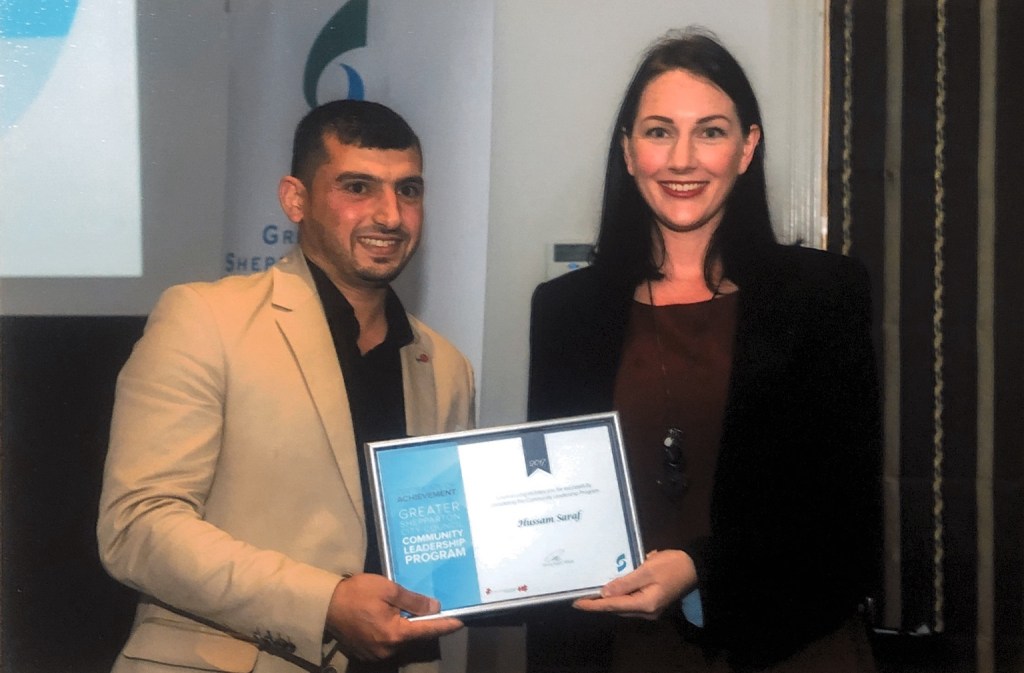 Hussam Saraf holding his 2017 Community Leadership Program certificate beside another attendee.