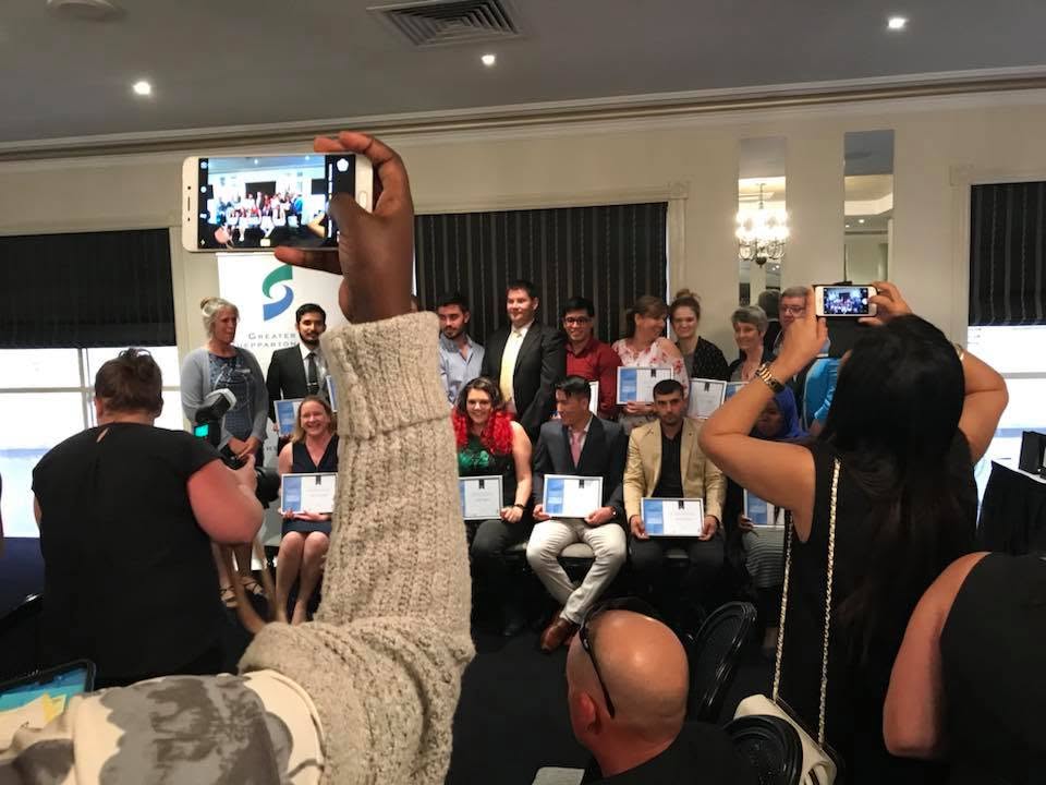 Guests photographing the 2017 graduates as Hussam Saraf and fellow participants pose with their certificates.