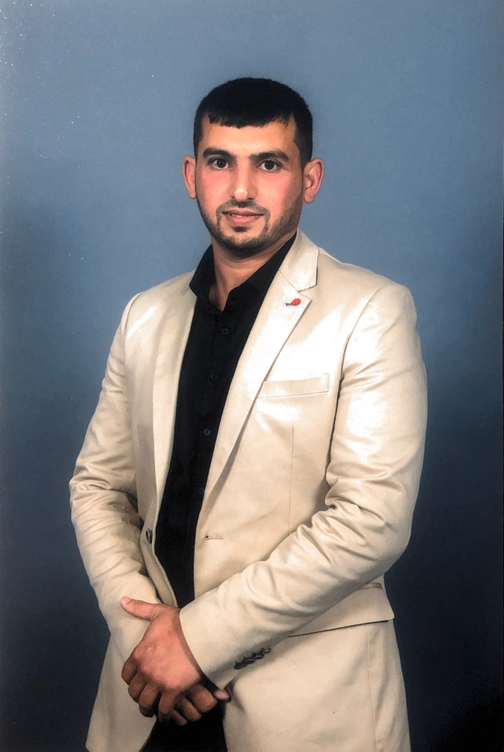A standing portrait of Hussam Saraf on Community Leadership Program graduation day in 2017.