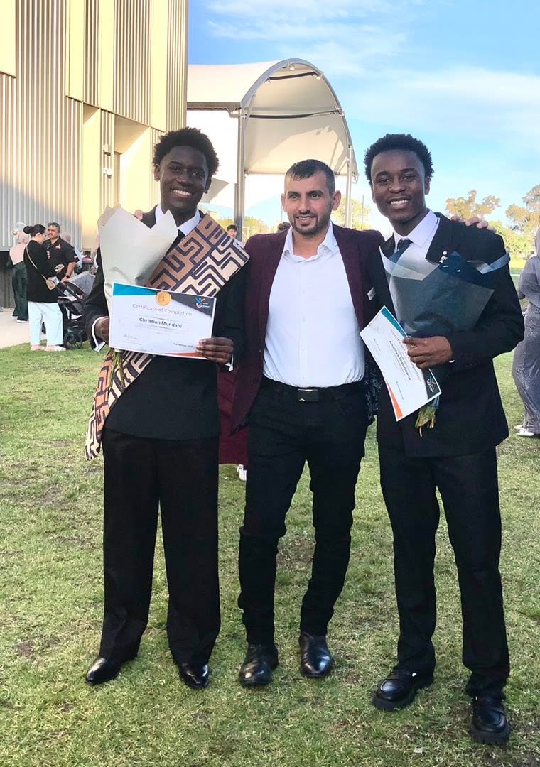 Three people standing on the lawn, with graduates holding certificates. GSSC Class of 2025.