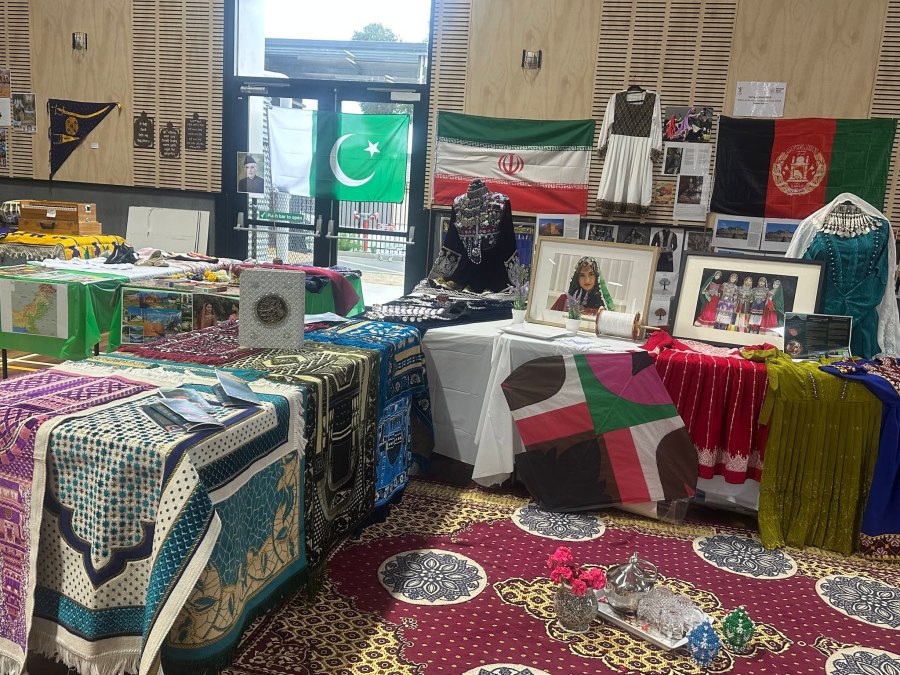 Cultural clothing, textiles, framed photographs and flags displayed at the GSSC Language Expo.