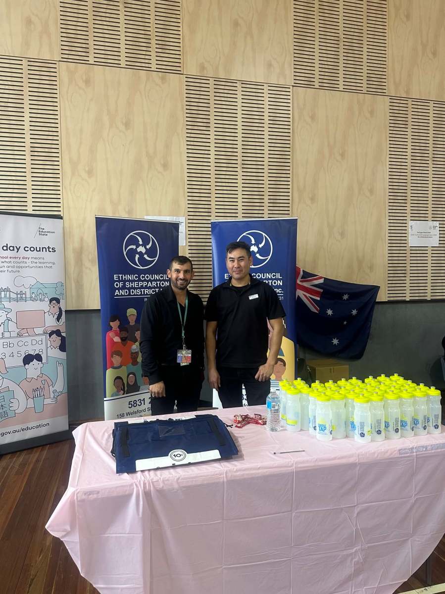 Two attendees standing beside the Ethnic Council information stall at the GSSC Language Expo.