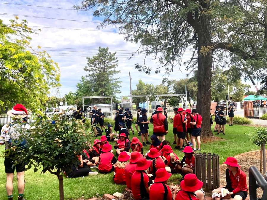 Visiting school groups sitting and standing on the lawn during the Aspirations Day lunch.