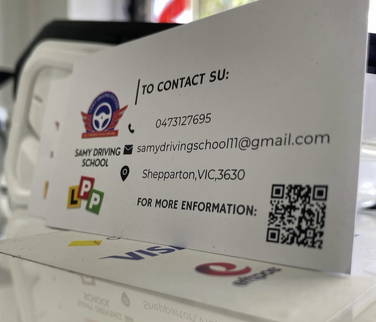 Close-up of a printed Samy Driving School business card featuring Hammood AL-Badry’s design.