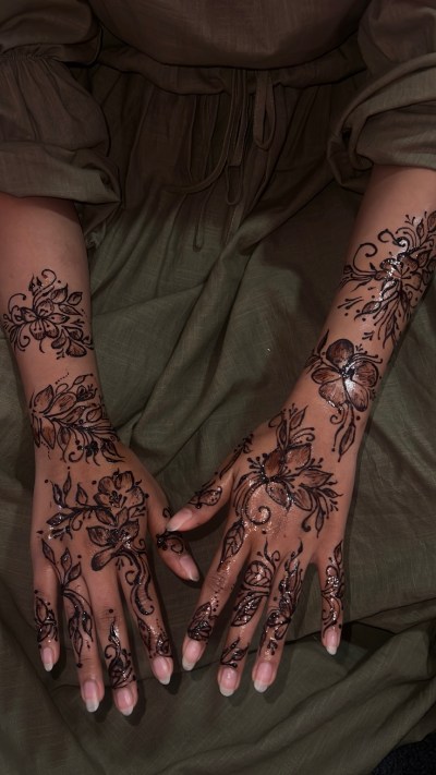 Henna by Diya: floral henna patterns across two hands and forearms.