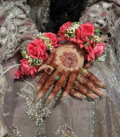 Henna by Diya: patterned hands with pink rose wrist accessories.