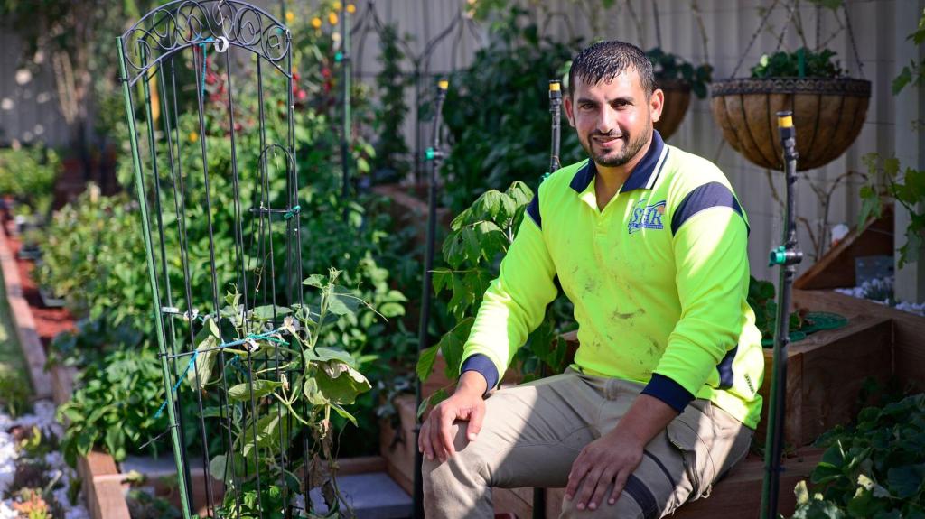 Hussam Saraf seated among plants in his garden.