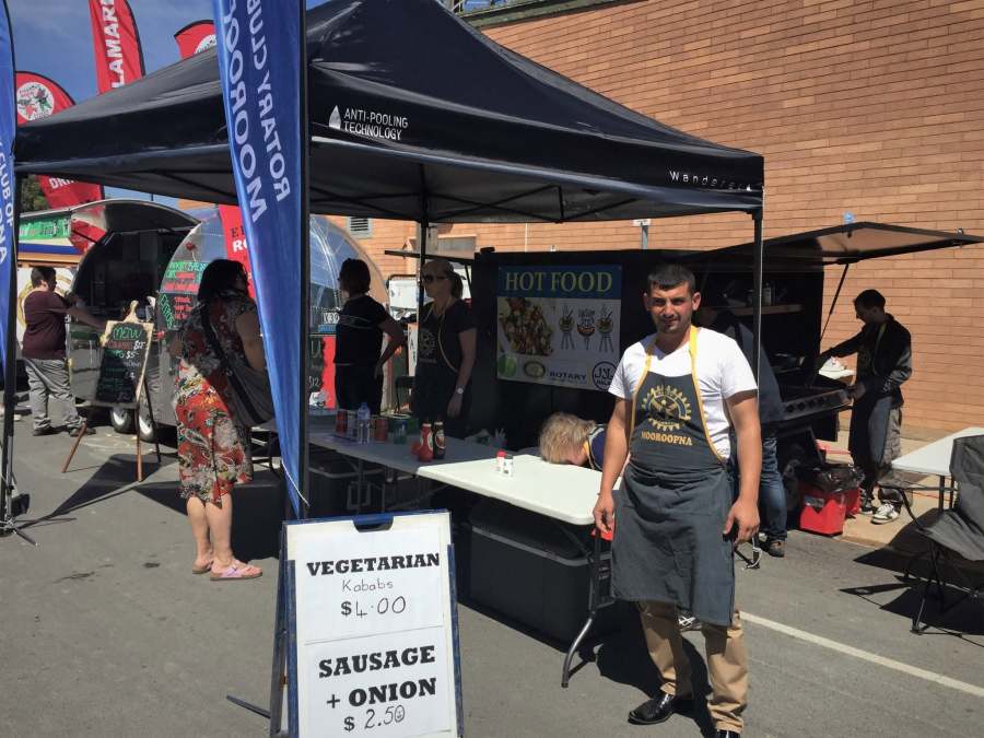 A volunteer in a Rotary Mooroopna apron outside the food stall and barbecue.
