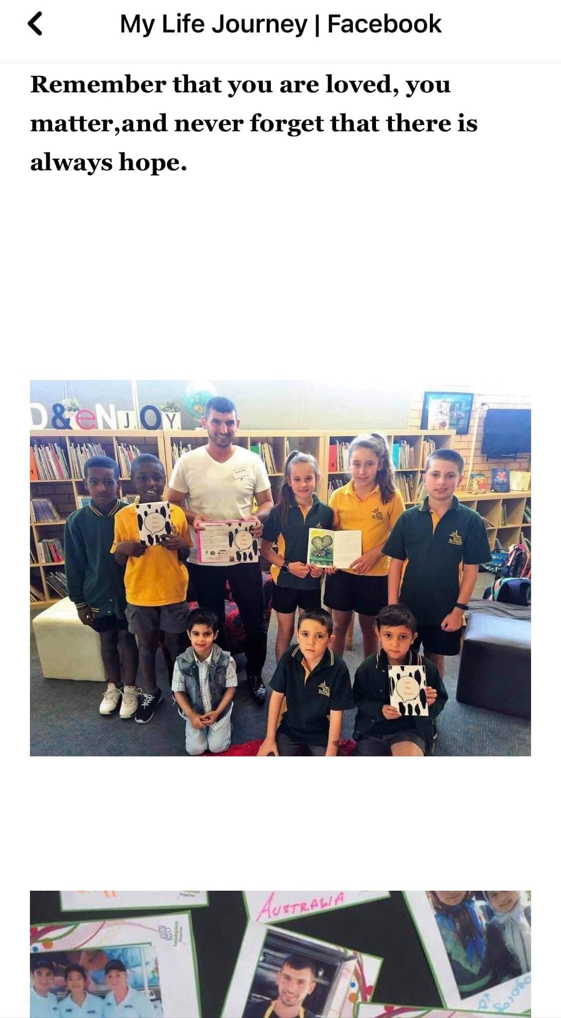 Hussam Saraf with a group of primary school pupils displaying their work.