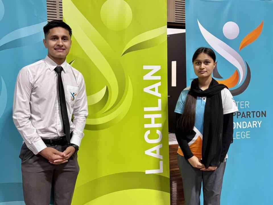 Two students standing beside Greater Shepparton Secondary College banners.