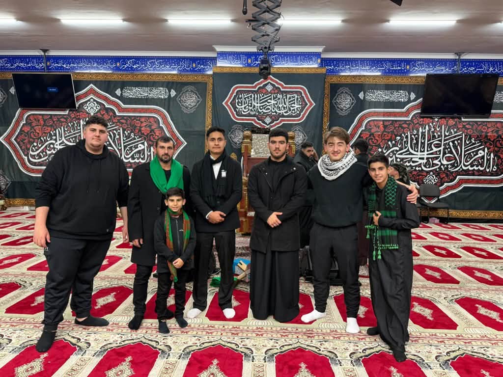 Community members standing together inside Imam Kadhim Mosque during an Ashura commemoration.