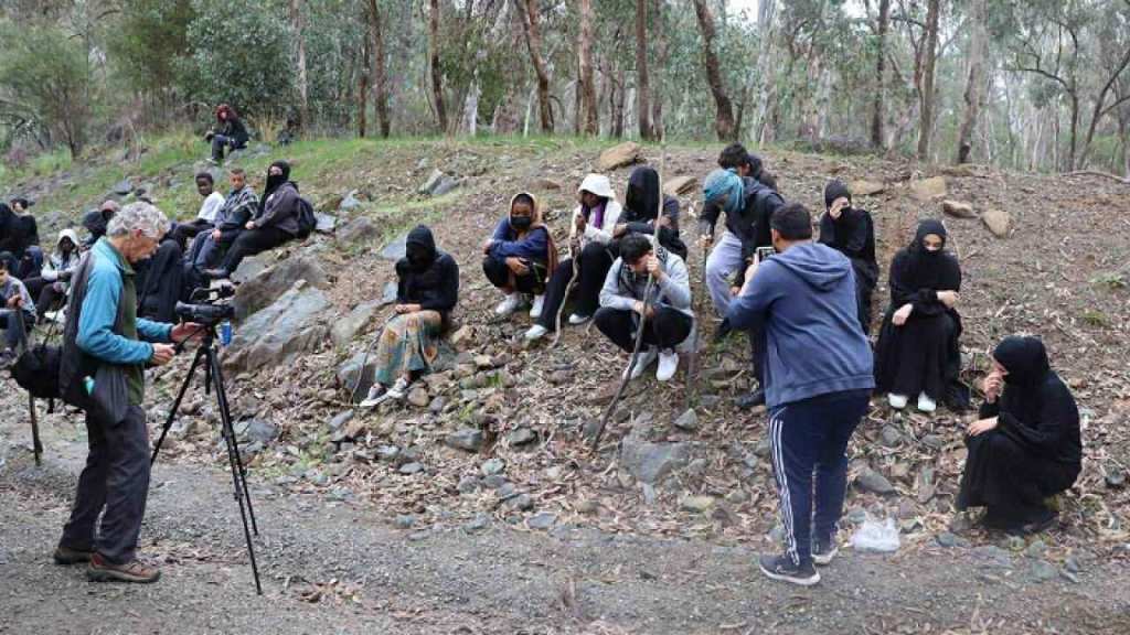 Film participants and camera crew working together in a woodland setting.
