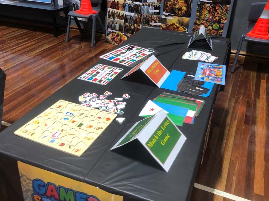 Arabic learning cards, colouring sheets and resources arranged on an activity table.