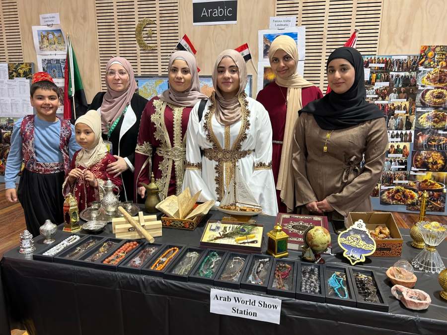 A group of students and educators gathered behind the Arabic station at the Expo.