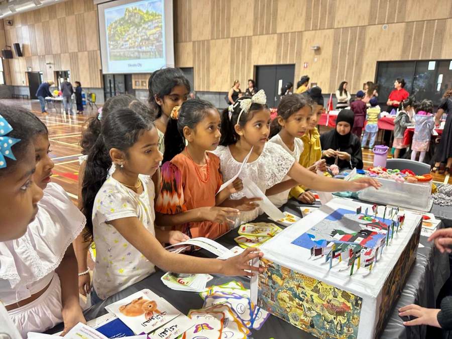Children exploring cards and a model at the Arabic station.