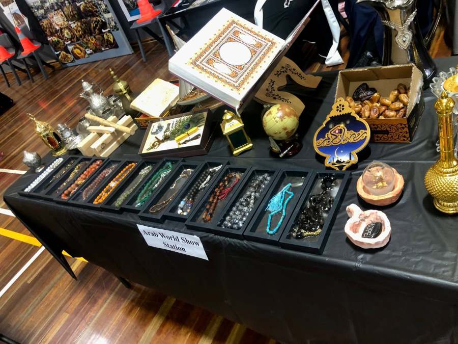 Calligraphy, beads and decorative objects arranged on a cultural display table.