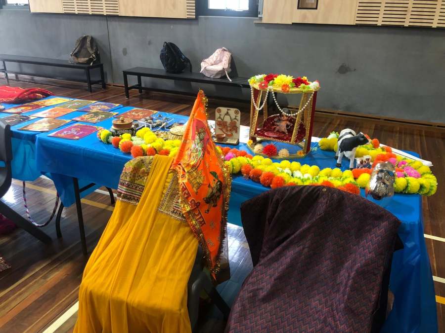 Brightly coloured clothing and garlands arranged beside cultural information.