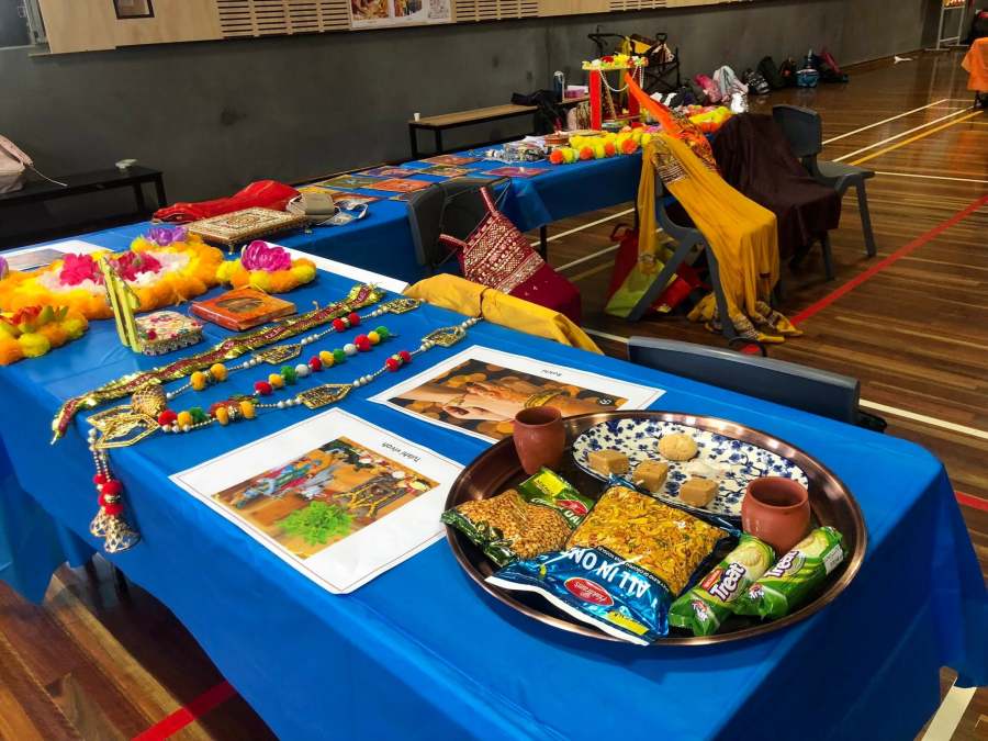Cultural clothing, photographs and decorative objects arranged across blue-covered tables.