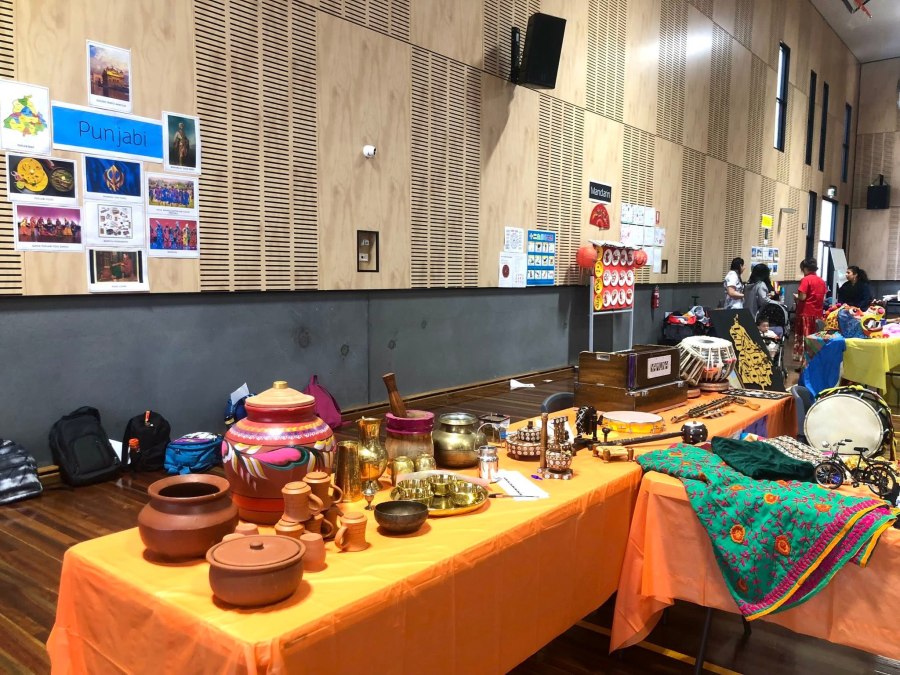 Food photographs, vessels and decorative objects on cultural display tables.