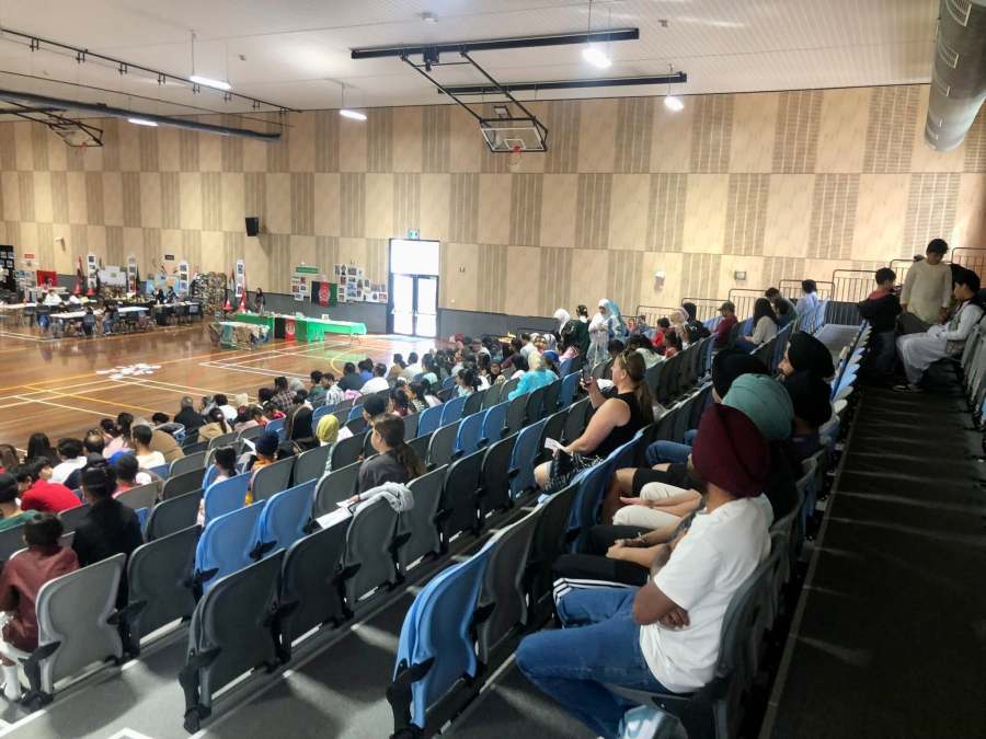 Community members seated in the hall facing the Expo programme.