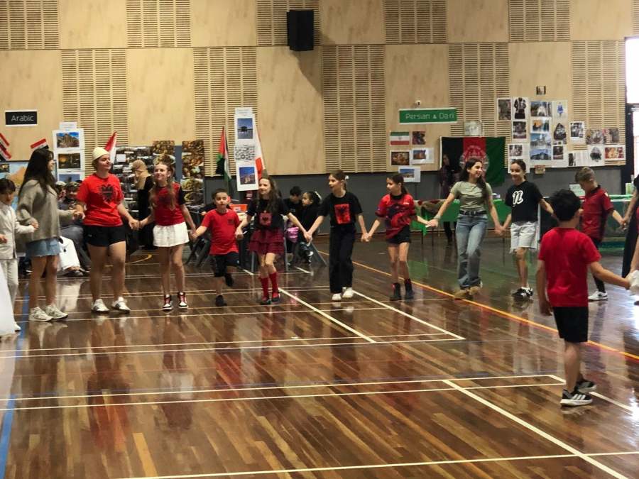 Students taking part in a group performance on the gymnasium floor.