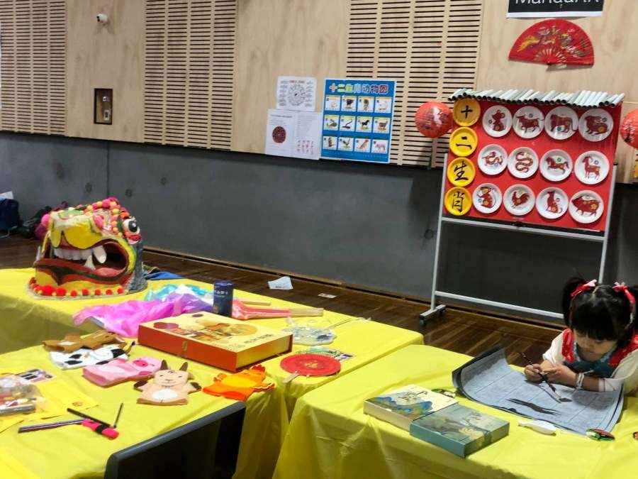 A visitor using learning materials beside a colourful language display.